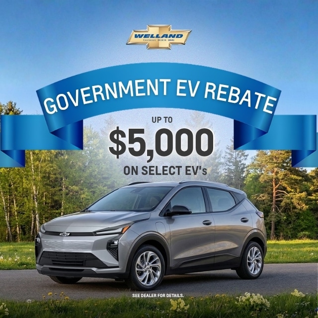 Chevrolet electric vehicle with a $5,000 government rebate offer against a forest backdrop.