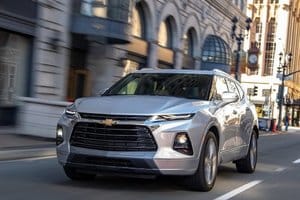 Chevrolet Blazer driving through a city street, showcasing its sleek design and modern features.