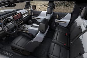 Interior view of a modern vehicle showcasing spacious seating, leather upholstery, a central touchscreen display, and advanced control features, designed for comfort and utility. Perfect for adventurous driving experiences.