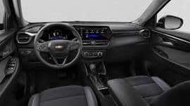Interior view of a Chevrolet vehicle showcasing a modern dashboard, digital display, and sleek black upholstery. The design emphasizes comfort and advanced technology features for an enhanced driving experience.